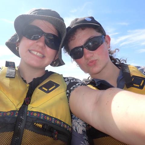 Two people in life jackets smiling at the camera
