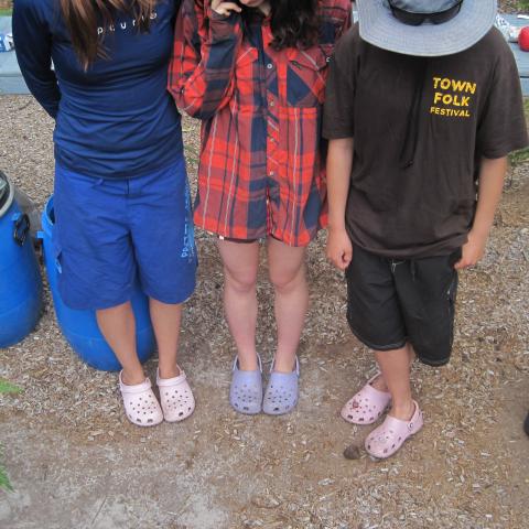 Three campers looking down at their feet